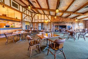 a restaurant with tables and chairs and a fireplace at Old Orchard Inn in Wolfville