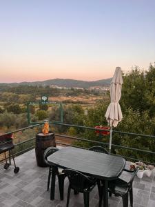 un patio con mesa y sombrilla en Refúgio dos Mauzinhos 