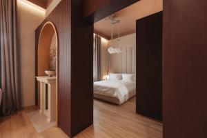 ein Hotelzimmer mit einem Bett und einem Flur in der Unterkunft Zenith Premium Suites in Thessaloniki