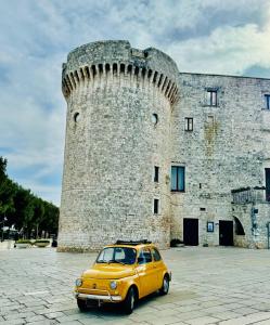 ein gelbes Auto, das vor einem Schloss geparkt ist in der Unterkunft A Casa di Luca in Conversano