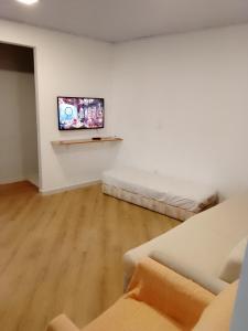 a living room with two beds and a flat screen tv at Flats do Cordeiro in Cabo Frio