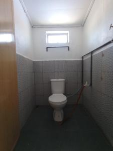 ein Bad mit einem WC und einem roten Schlauch in der Unterkunft Seahorse Diver Guesthouse in Perhentian Island