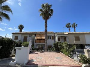 a house with a palm tree in front of it at Casa vacanze Kastalia - Rossa in Ragusa