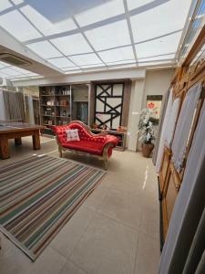 a living room with a red couch and a rug at Casa no pé da Serra da Cantareira in Sao Paulo