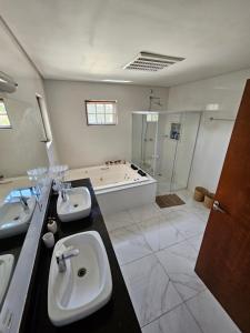 a bathroom with two sinks and a bath tub at Casa no pé da Serra da Cantareira in São Paulo