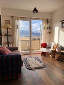 a living room with a couch and a large window at Potken - Depto vistas increíbles, cálido y acogedor in Ushuaia