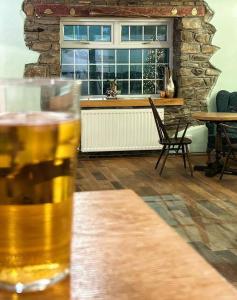 Penybont Restaurant + Inn في كرمرثن: كوب من البيرة موجود فوق طاولة