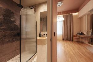 ein Bad mit einer Glasdusche und einem Tisch in der Unterkunft Zenith Premium Suites in Thessaloniki
