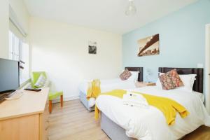 a bedroom with a bed and a desk and a tv at Temple Apartment by Beds Away in Oxford