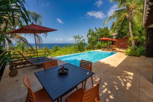 un patio con mesa y sillas y una piscina en Hotel Acantilado de La Tierra en San Andrés