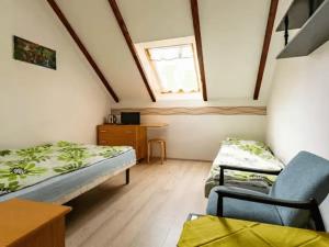 a room with two beds and a chair in it at B&B Artemida in Ostrowo