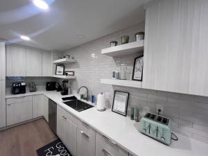 a kitchen with white cabinets and a white counter top at Evans-Clark Manor in Indianapolis +20 photos
