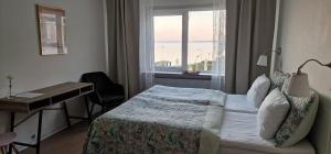 1 dormitorio con cama, escritorio y ventana en Hotel Udsigten Marstal, en Marstal