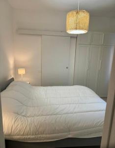 a white bed in a bedroom with a light fixture at Civico 45 in Ancona