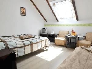 a bedroom with a bed and a chair and a window at B&B Artemida in Ostrowo