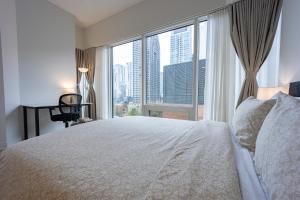 a bedroom with a large bed and a large window at AAA Location & Spacious 1 Bedroom with Panoramic View on the City in Montréal +17 photos