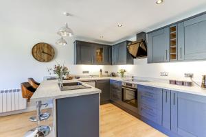 cocina grande con armarios azules y encimera en The Old Warehouse Ely "Apartments", en Ely