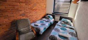 Pokój z 2 łóżkami i ceglaną ścianą w obiekcie M Hostel w mieście Gliwice