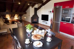 una cucina e una sala da pranzo con tavolo e camino di Casa rural Urederra 1 y 2, en Baquedano, donde inicia la ruta del Nacedero del Urederra a Baquedano