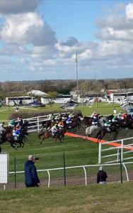 a group of horses racing on a race track at Aintree Grand National Home in Aintree