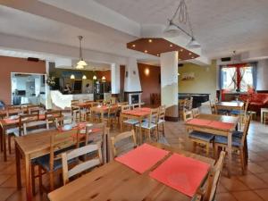 a restaurant with wooden tables and chairs and a kitchen at B&B Artemida in Ostrowo