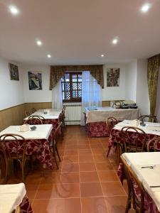 a restaurant with tables and chairs and a room with beds at Claudia B&B in Pescasseroli