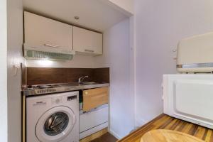 a kitchen with a washing machine and a sink at Cocon au cœur d'Antibes in Antibes