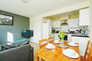 a living room with a wooden table and a kitchen at Temple Apartment by Beds Away in Oxford