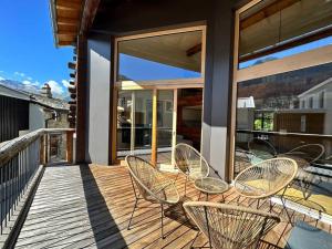 a patio with chairs and tables on a deck at Stylish chalet w/Sauna: Alpine escape in Tinzen