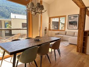 a dining room with a table and chairs and a couch at Stylish chalet w/Sauna: Alpine escape in Tinzen