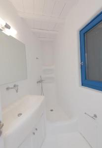 W białej łazience znajduje się umywalka i lustro. w obiekcie Mykonian Private 2 Bd Villa with Private Pool w mieście Ftelia