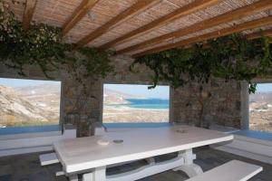 Biały stół w pokoju z dwoma oknami w obiekcie Mykonian Private 2 Bd Villa with Private Pool w mieście Ftelia