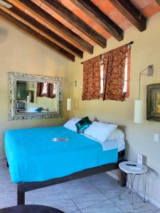 a bedroom with a blue bed and a mirror at Amaria Villas in Puerto Vallarta