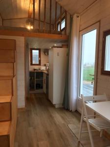 Zimmer mit einer Küche, einem Tisch und einem Fenster in der Unterkunft Tiny house à la ferme près Paris et center parcs. in Boissy-sur-Damville