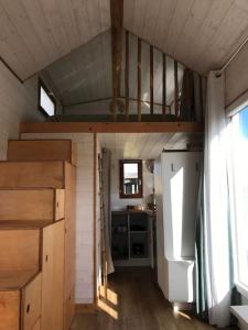 Tiny house à la ferme près Paris et center parcs. في Boissy-sur-Damville: غرفة صغيرة مع سرير بطابقين في منزل صغير