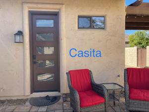 zwei Stühle vor einem Gebäude mit einer Tür in der Unterkunft Guesthouse/Casita Goodyear in Goodyear