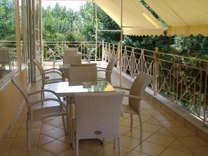 a restaurant with tables and chairs on a balcony at Galini in Loutra Edipsou