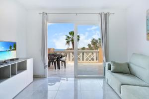 een woonkamer met een glazen schuifdeur naar een patio bij Luxury Romantic Ocean View in Adeje