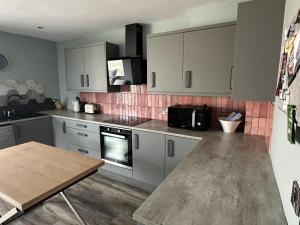 a kitchen with white cabinets and a wooden table at Distillery House in Bushmills +16 photos