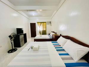 ボラカイにあるLA FIESTA RESORTの大型ベッドとテレビが備わるホテルルームです。