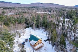 an aerial view of a house in the snow at 65PT New Log Cabin in Private Setting. Hot tub. Gym/Pool Access! in Twin Mountain