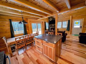 kuchnia i jadalnia w drewnianym domku w obiekcie 65PT New Log Cabin in Private Setting. Hot tub. Gym/Pool Access! w mieście Twin Mountain