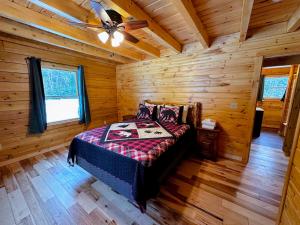 sypialnia z łóżkiem w drewnianym domku w obiekcie 65PT New Log Cabin in Private Setting. Hot tub. Gym/Pool Access! w mieście Twin Mountain