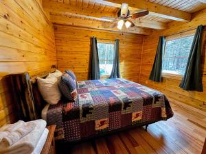 a bedroom with a bed in a log cabin at 65PT New Log Cabin in Private Setting. Hot tub. Gym/Pool Access! in Twin Mountain
