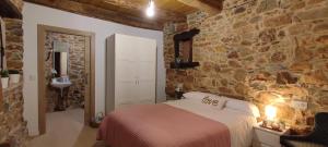 a bedroom with a bed and a stone wall at la solana del abuelo Andrés 