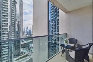 balcón con mesa, sillas y vistas a la ciudad en MAJESTIC Act Two 2BR- 27th Floor Burj Khalifa- Downtown Dubai, en Dubái