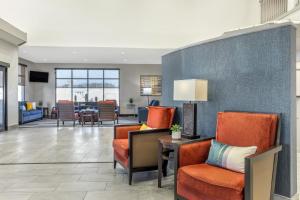 een lobby met oranje stoelen en een woonkamer bij Comfort Suites Nacogdoches in Nacogdoches