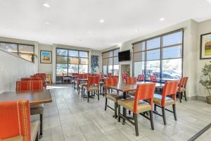 a dining room with tables and chairs and windows at Comfort Suites Nacogdoches in Nacogdoches