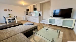 a living room with a couch and a flat screen tv at Ferienwohnung Panoramablick in Erbach im Odenwald