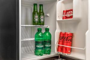 um frigorífico cheio de garrafas verdes de refrigerante em 5Terre dei Poeti Plus em La Spezia